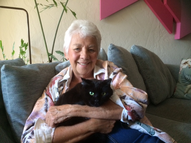 Woman holding her black cat.