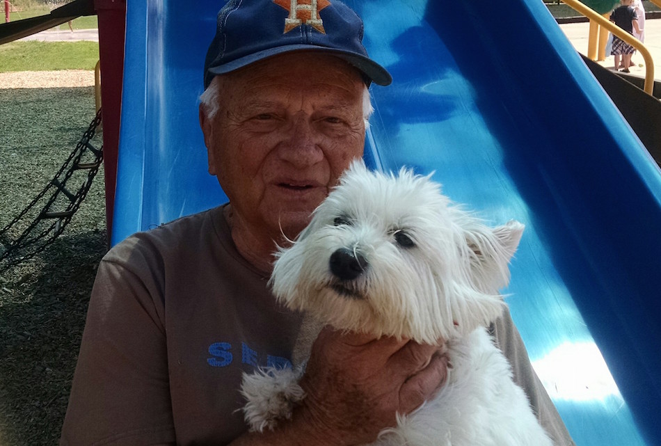 Man holding his white dog.